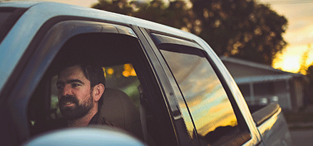 Man driving a pickup truck.